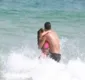 
                  Nicole troca beijos com namorado em praia e quase perde biquíni