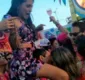 
                  Folião beija outra enquanto leva mulher nos ombros e vira meme